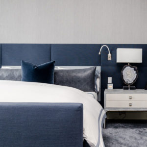 Bedroom showing a blue bedframe and nightstand with a lamp