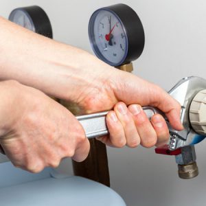 Hands repairing valves in boiler room
